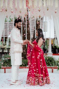 A man and woman standing under a canopy of flowers