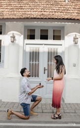 A man kneeling down next to a woman