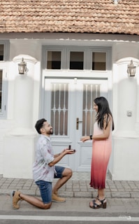 A man kneeling down next to a woman