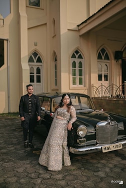 A man and a woman standing next to a car