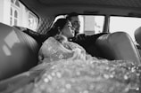 A man and woman sitting in the back of a car
