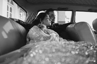 A man and woman sitting in the back of a car
