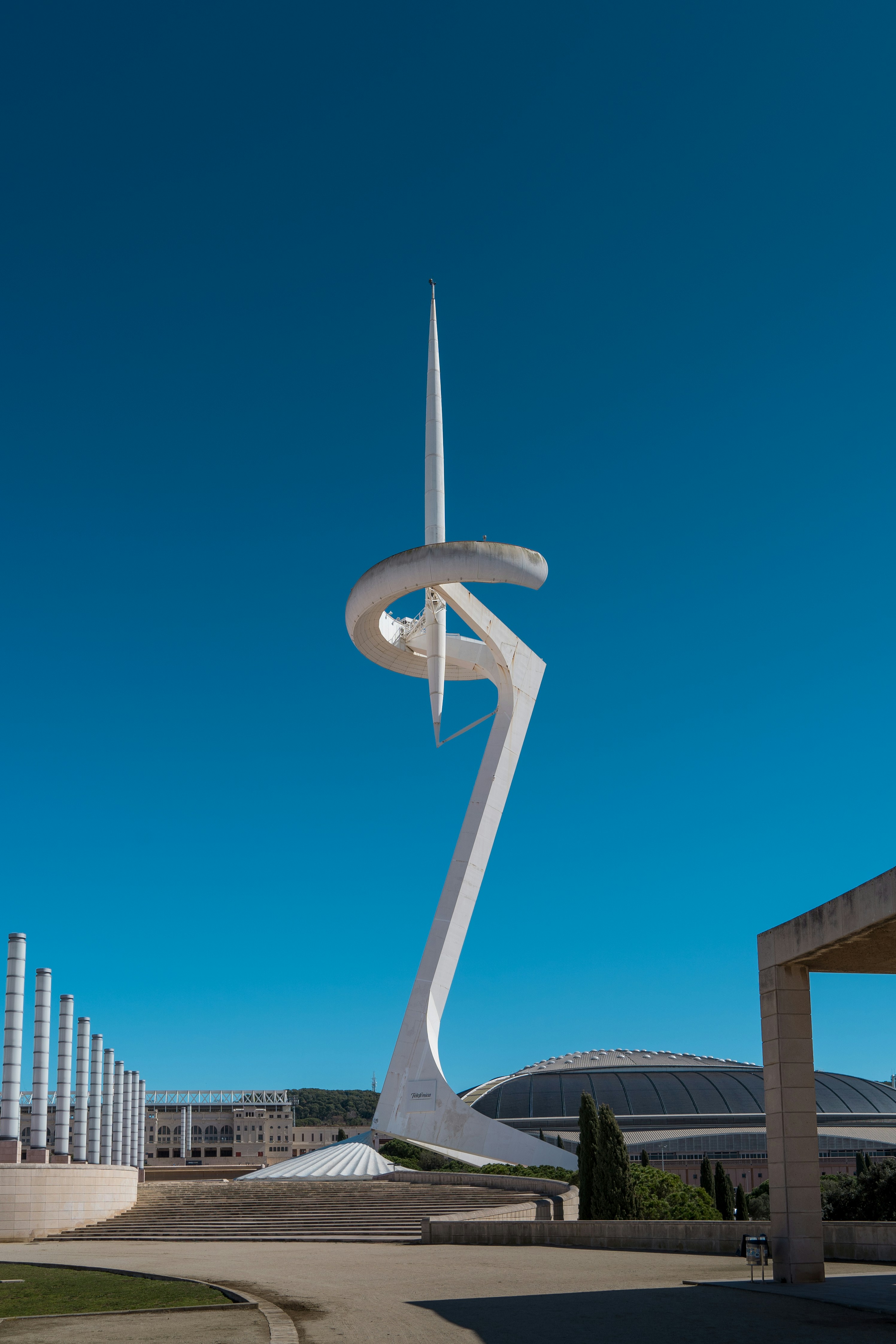 A tall white sculpture sitting in the middle of a park