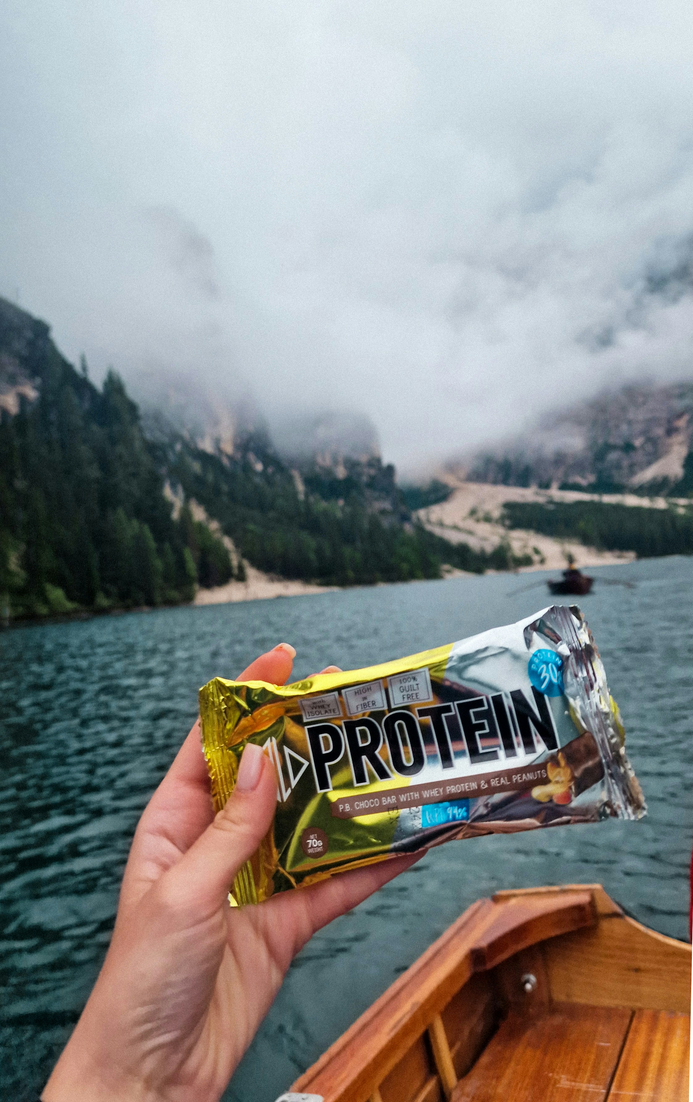 A person holding a bar of protein bar on a boat