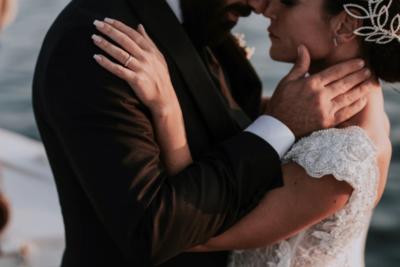 A bride and groom intimately embracing on a private boat in the waters off Positano on the Amalfi Coast Italy with the sea visible behind them