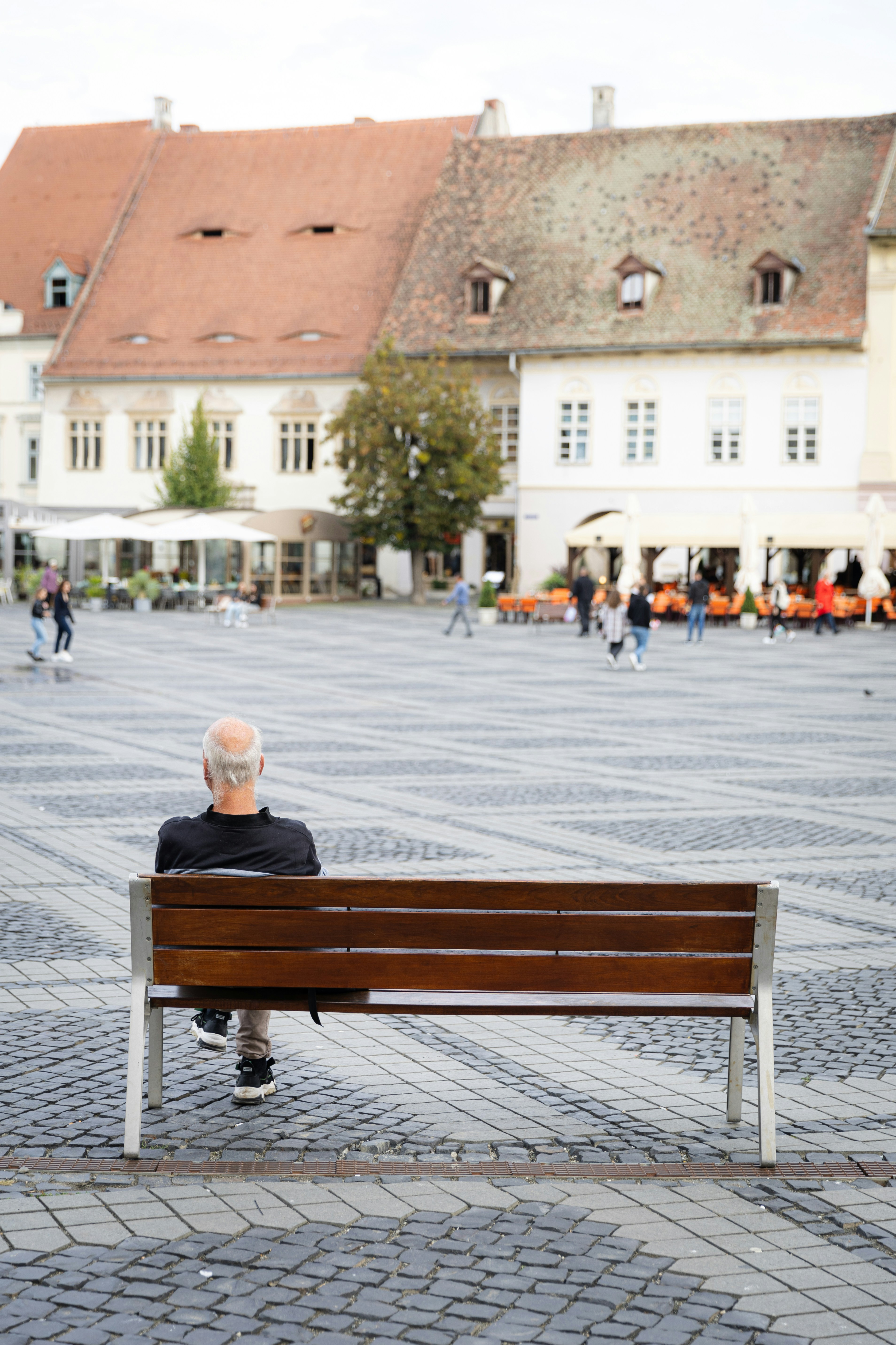 A man sitting on a bench in a courtyard