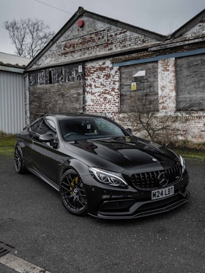 A black car parked in front of a building