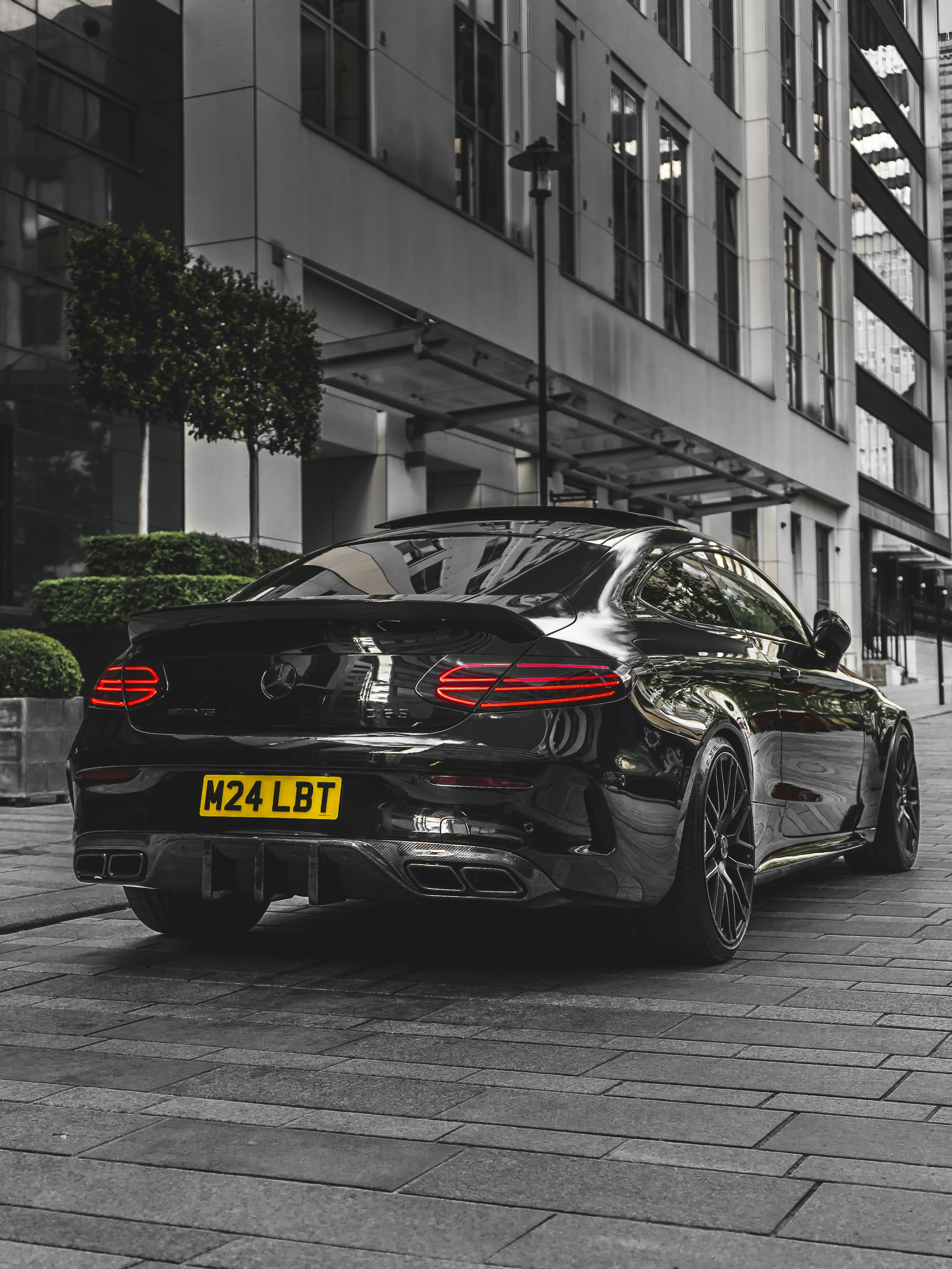 A black car parked in front of a tall building