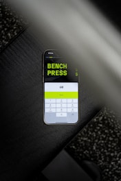 A cell phone with a bench press sticker on it