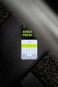 A cell phone with a bench press sticker on it