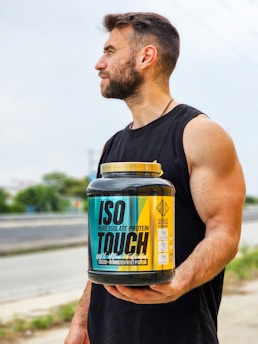 A man is holding a jar of protein