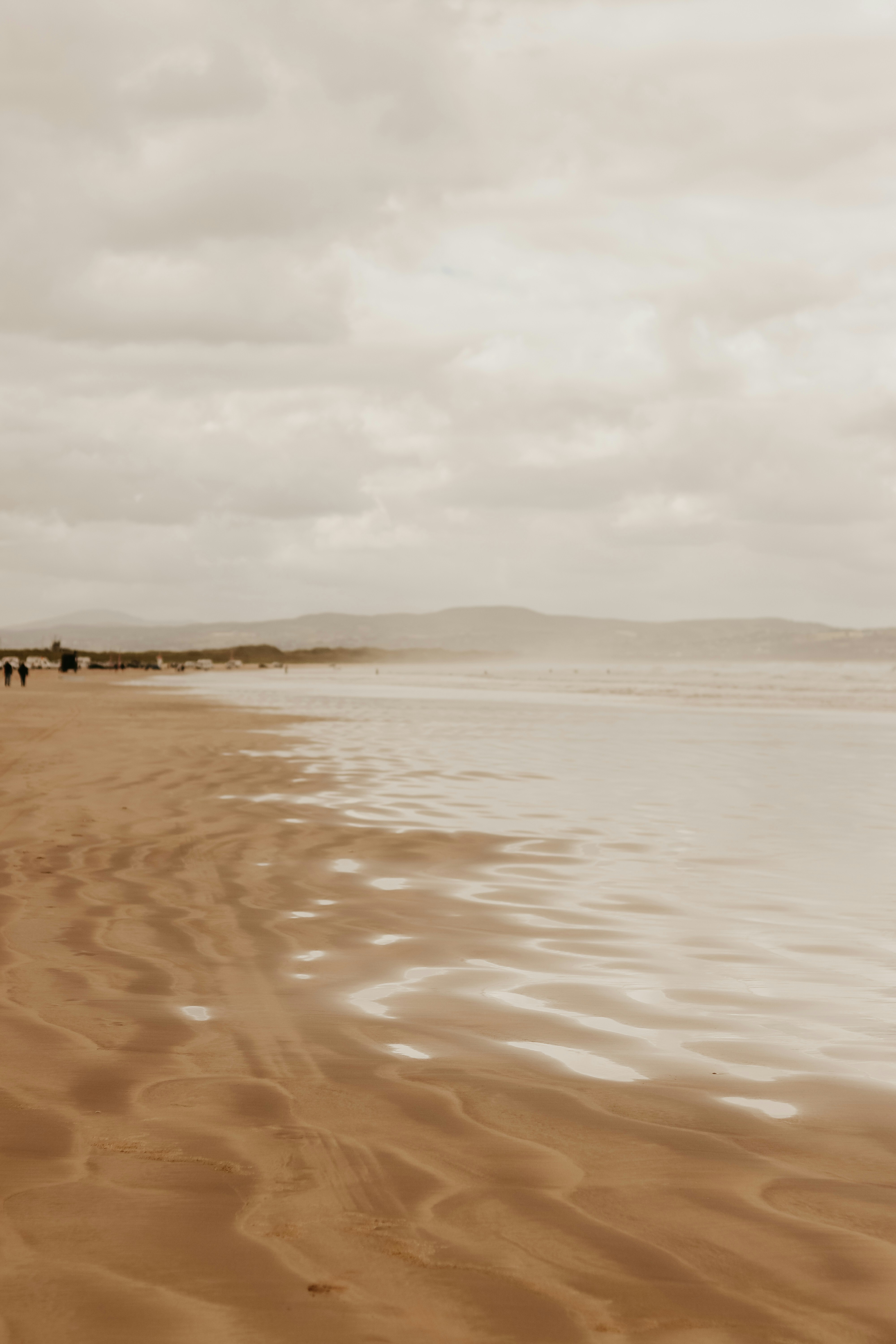 Une personne marchant sur une plage avec une planche de surf