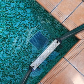 A pair of blue brushes sitting on top of a tiled floor