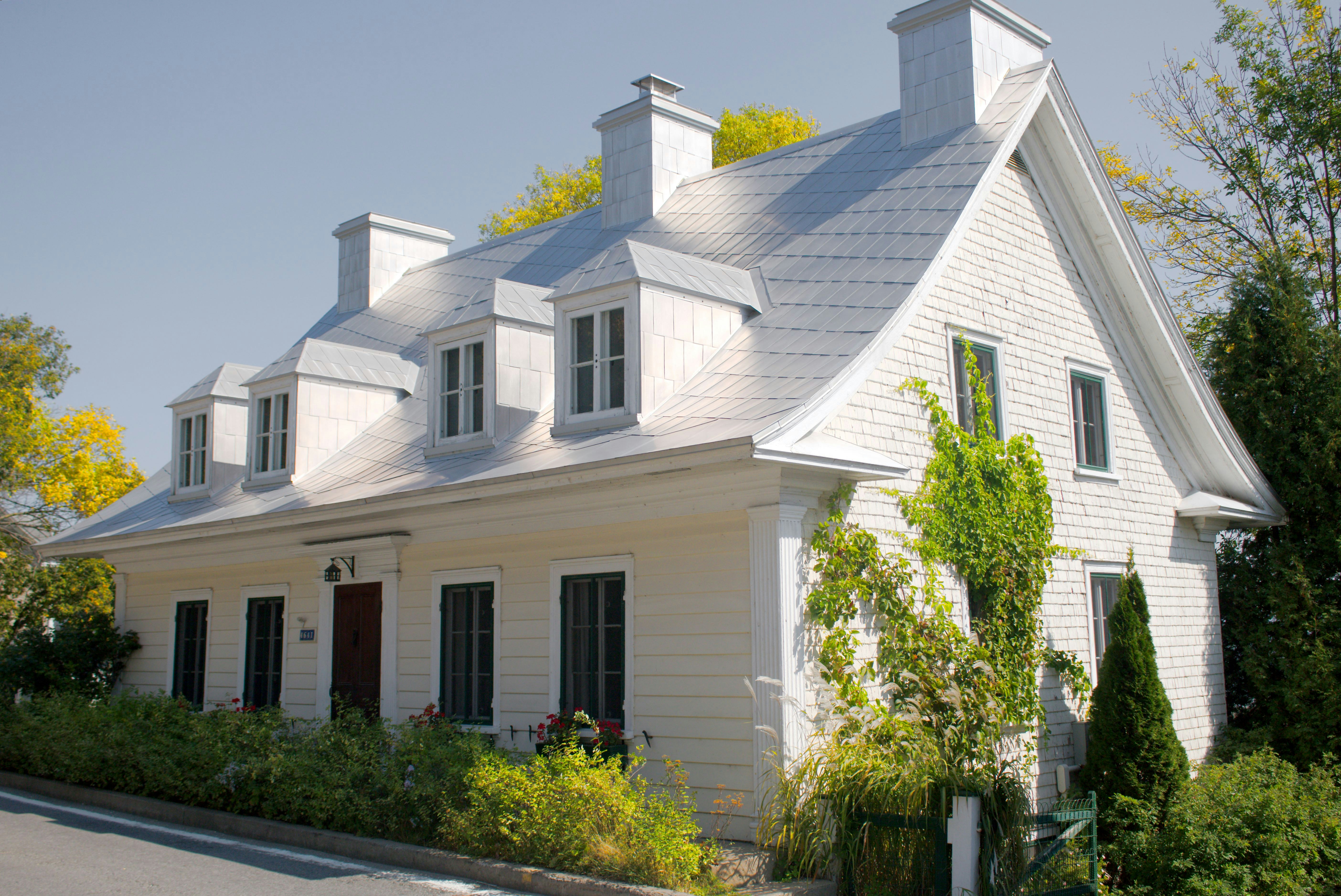 A white house with black shutters and a red door