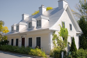 A white house with black shutters and a red door