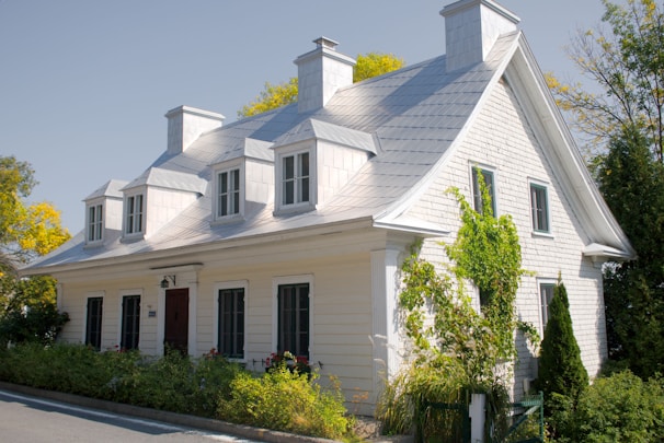 A white house with black shutters and a red door