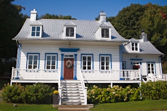 A white house with blue trim and a red door