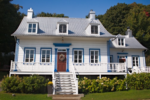 A white house with blue trim and a red door