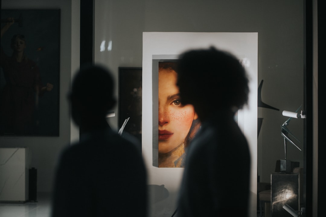 A couple of people standing in front of a picture,