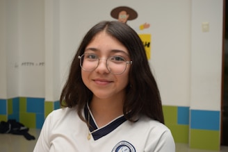 A girl with glasses is posing for a picture