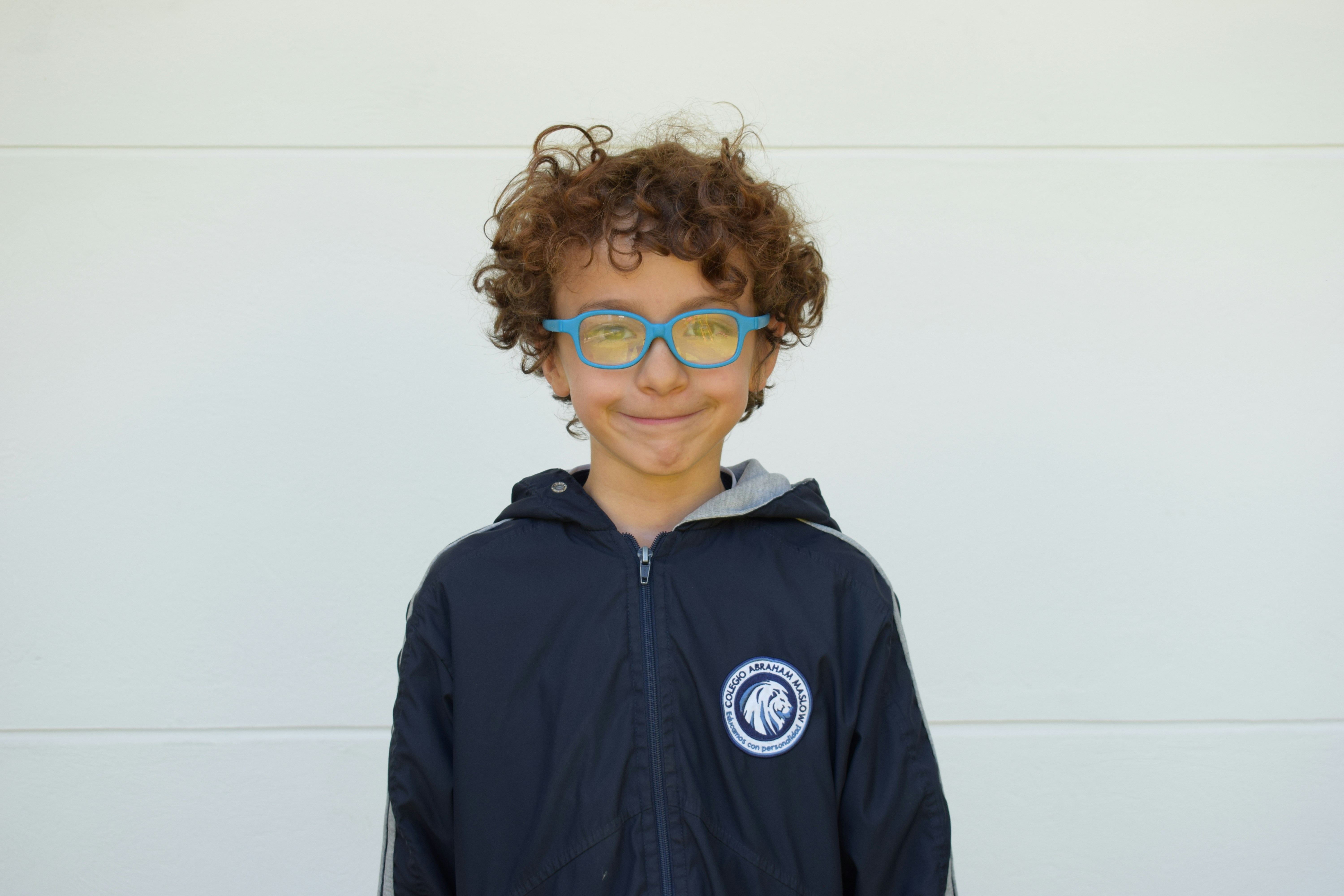 A young boy wearing sunglasses and a jacket