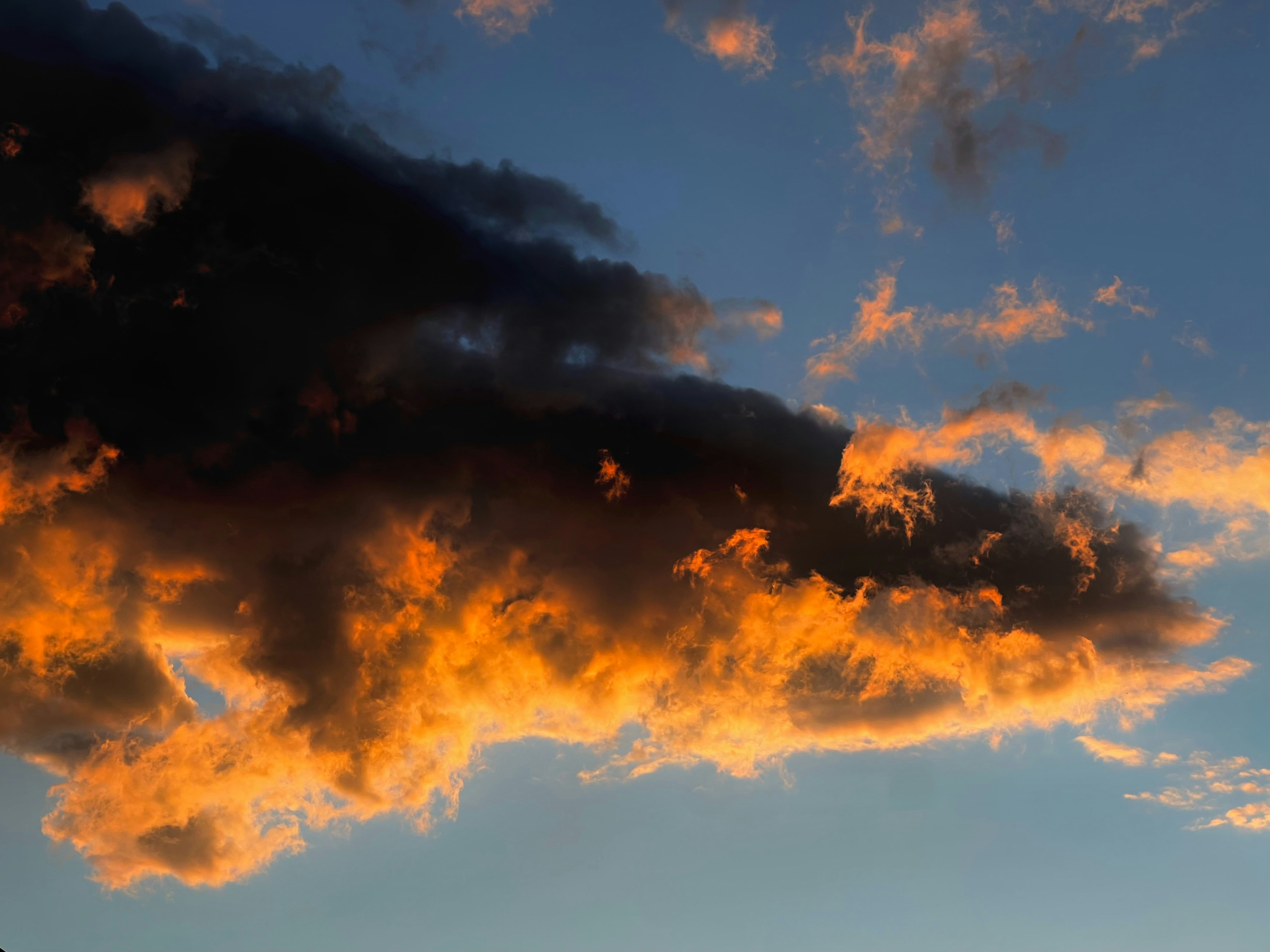 A plane flying in the sky at sunset