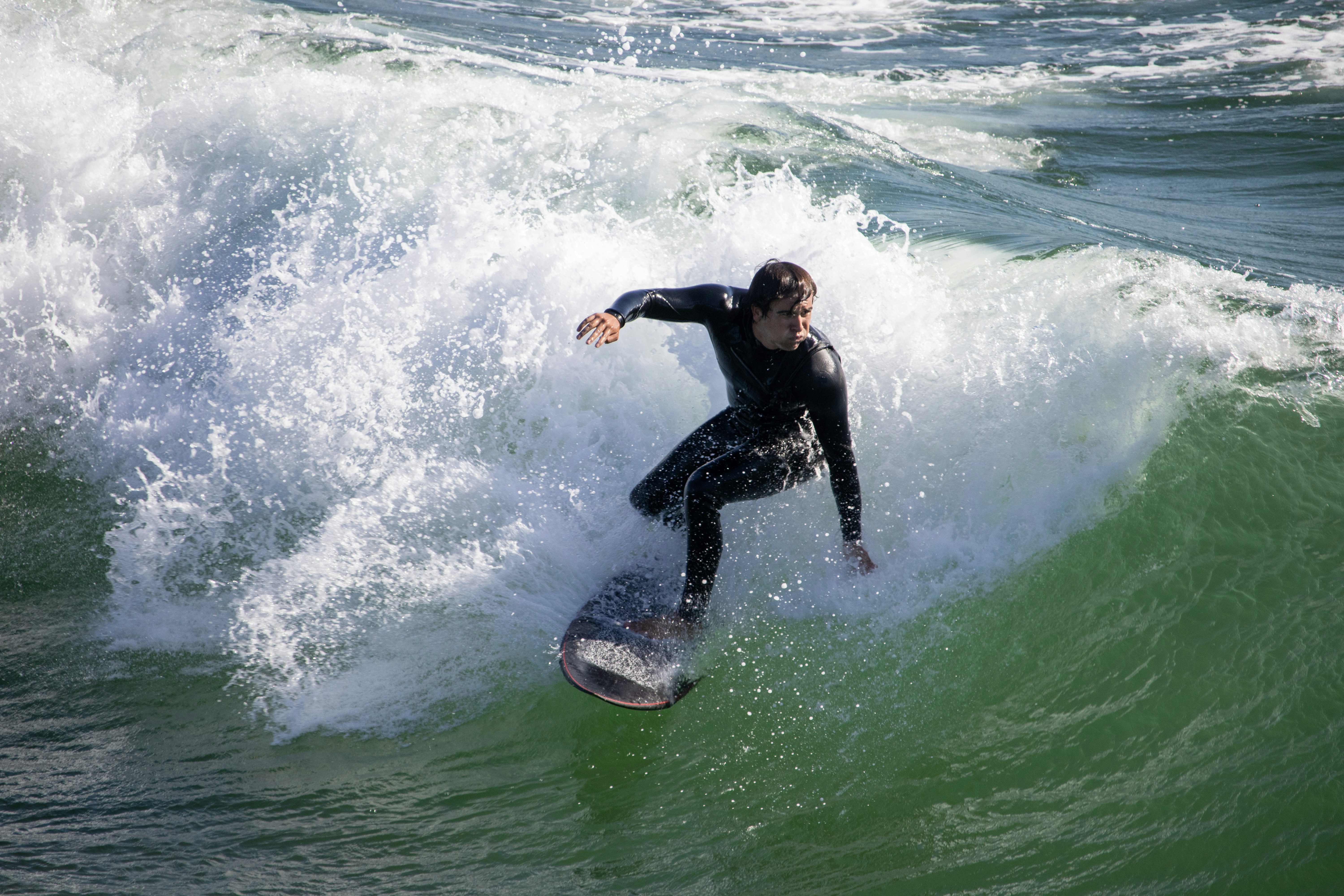 Un hombre montando una ola encima de una tabla de surf