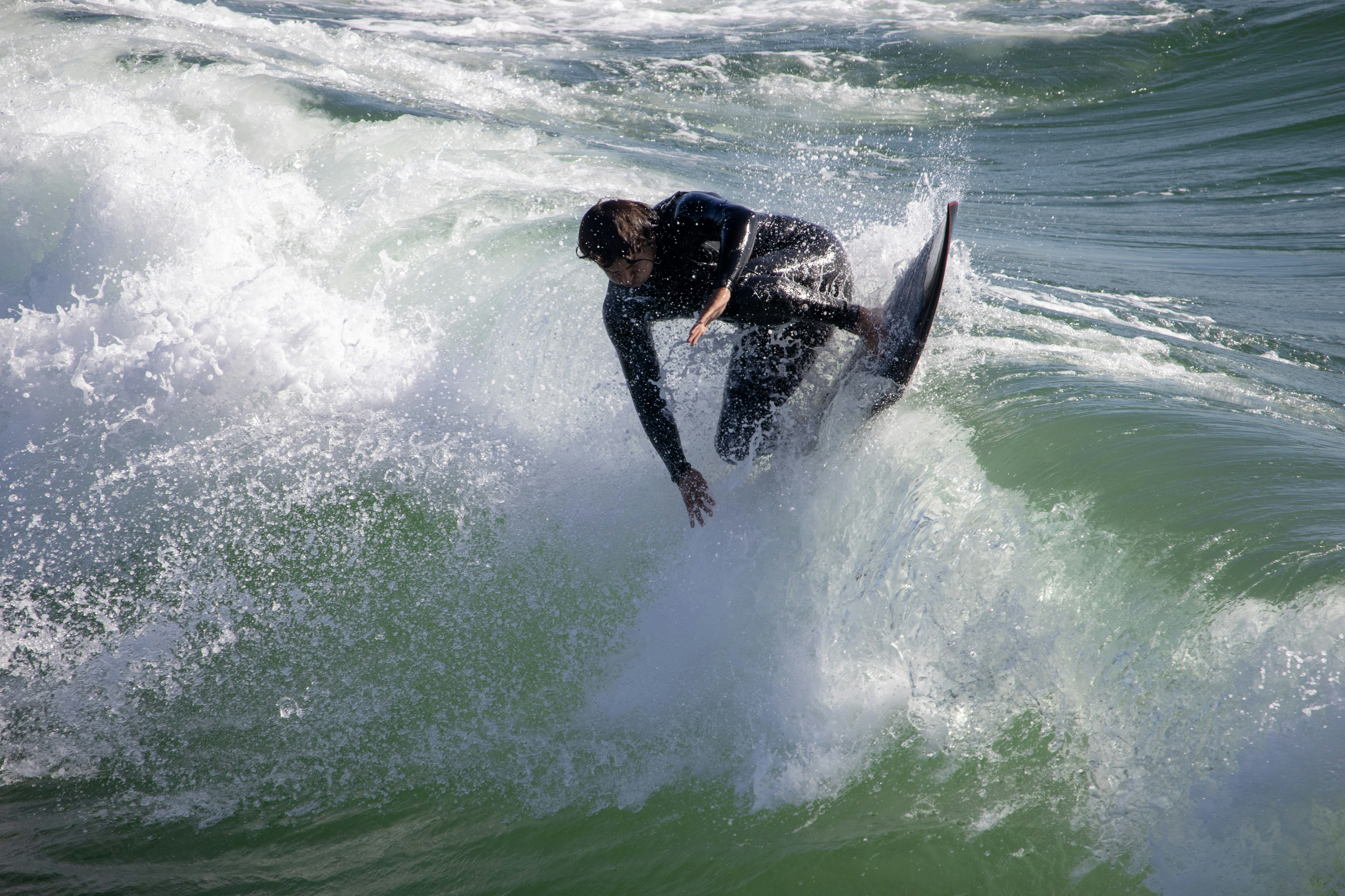 Un hombre montando una ola encima de una tabla de surf