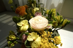 A vase filled with yellow and pink flowers