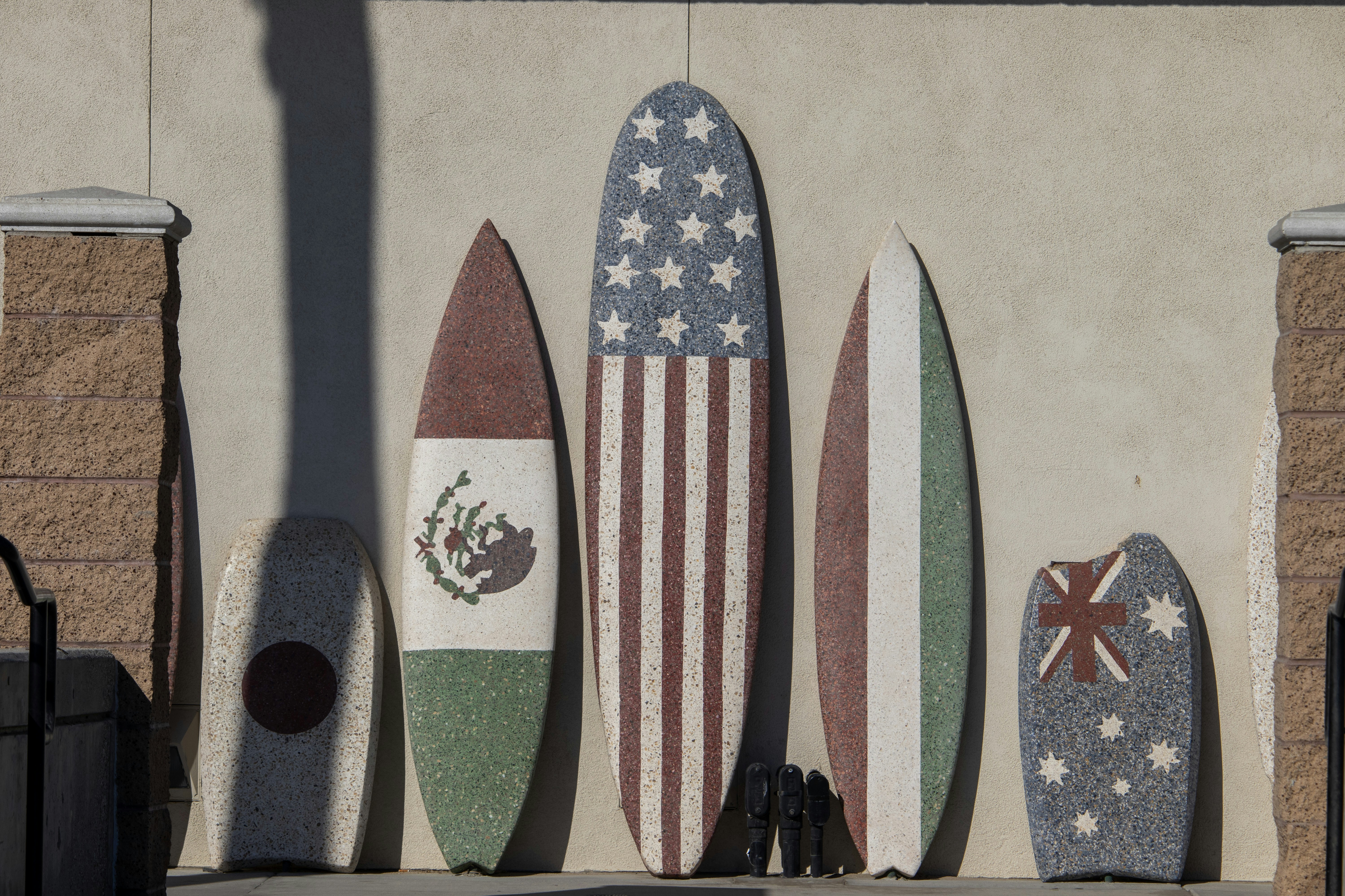 Un montón de tablas de surf están alineadas contra una pared