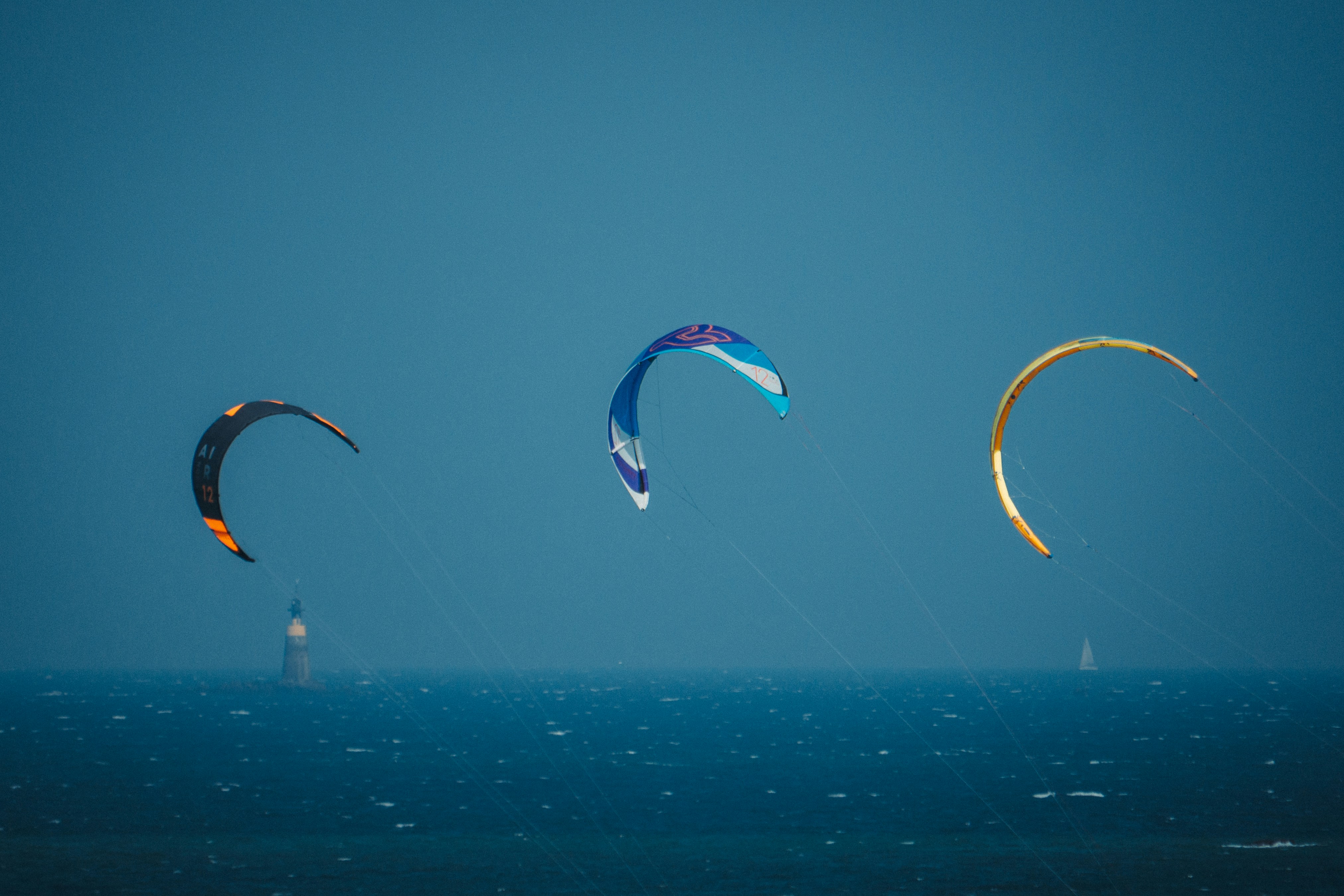 A group of kites flying over the ocean