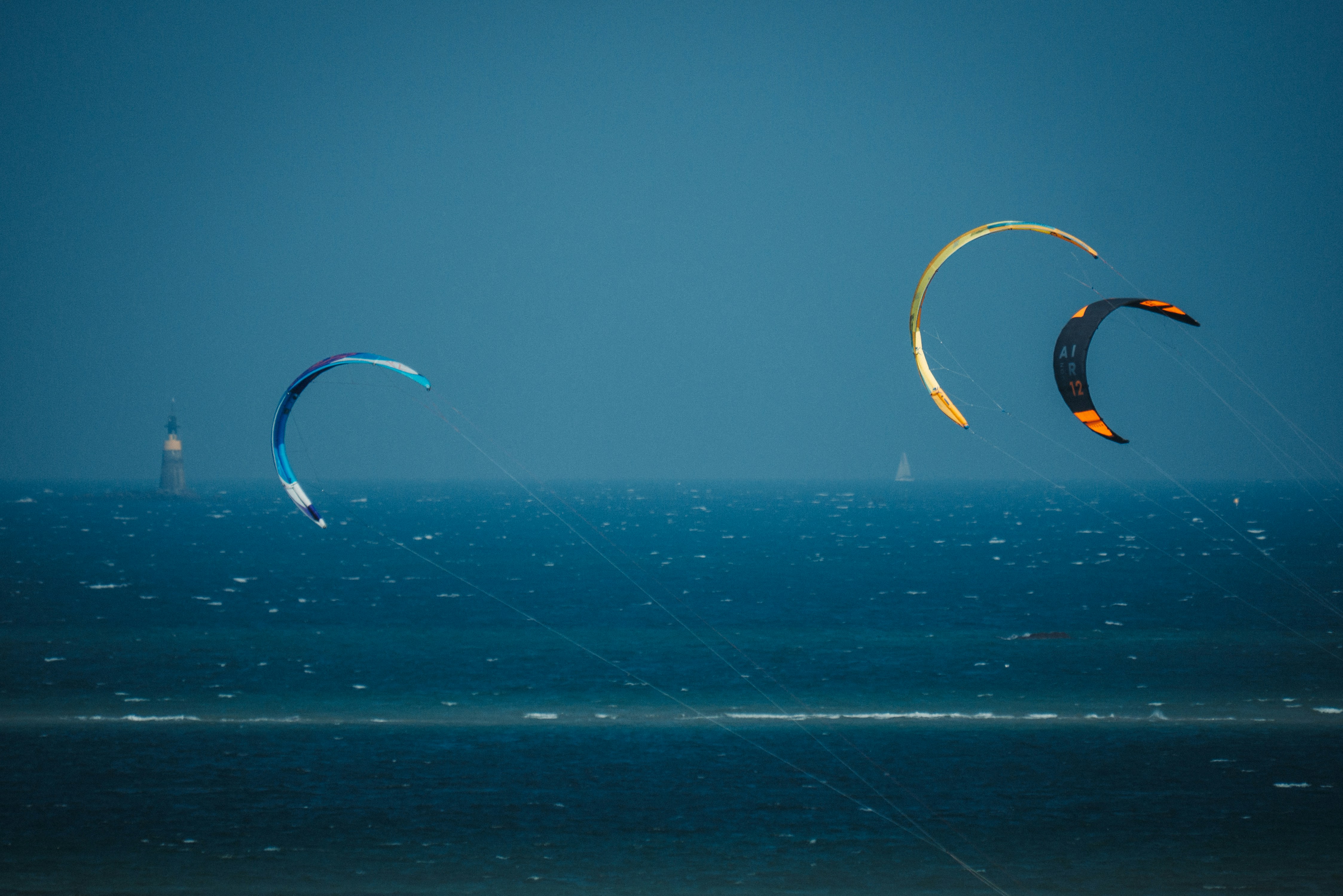A group of people flying kites over the ocean
