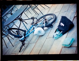 A blue bicycle parked on top of a wooden floor