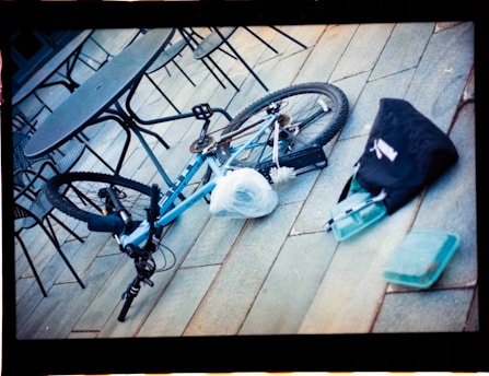 A blue bicycle parked on top of a wooden floor