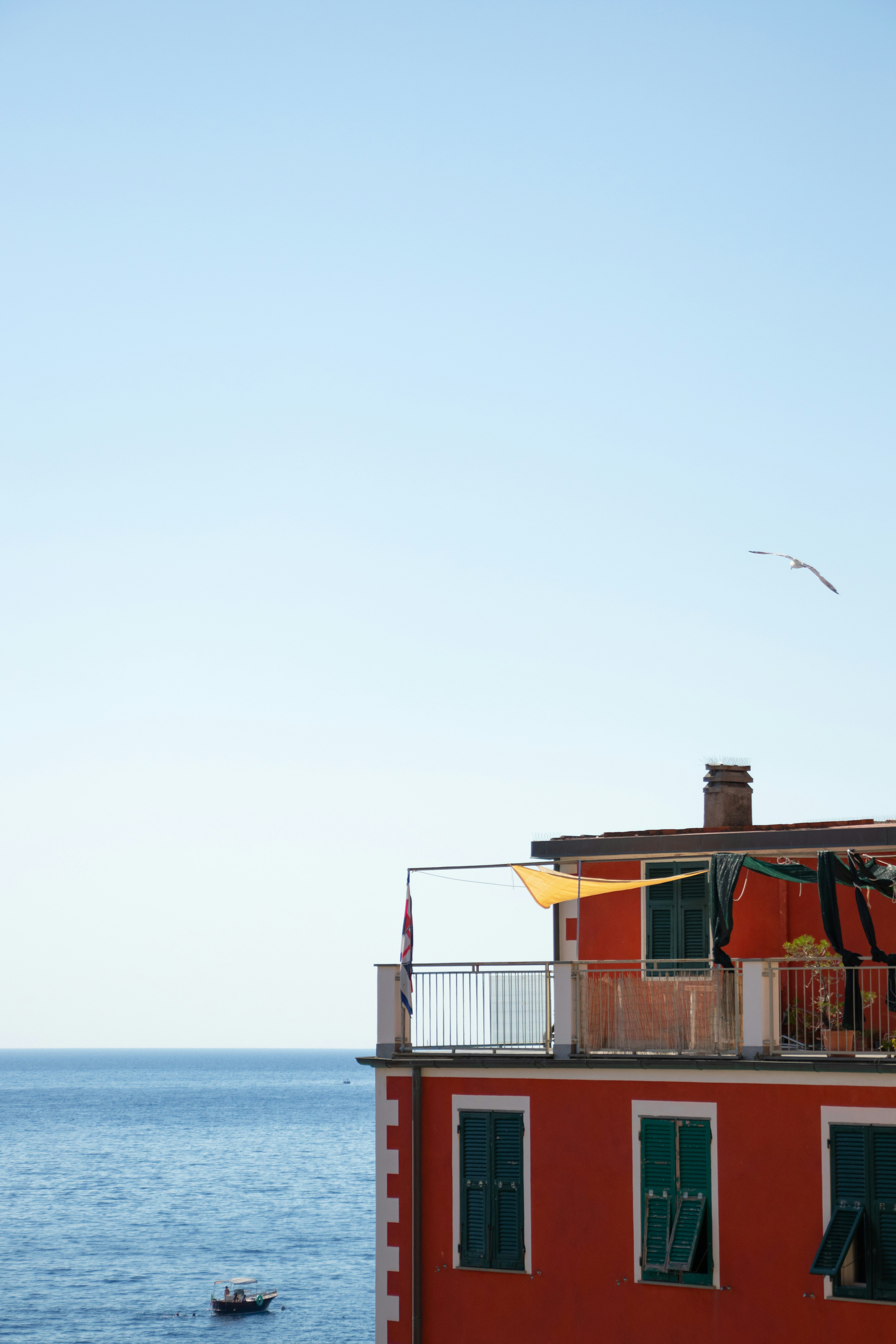 A red building with a balcony overlooking the ocean