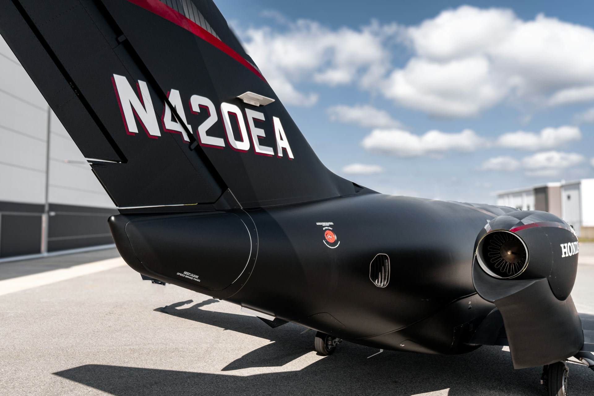 A black airplane sitting on top of an airport tarmac