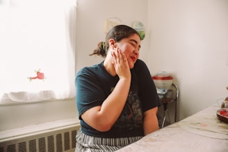 A woman standing in a kitchen talking on a cell phone
