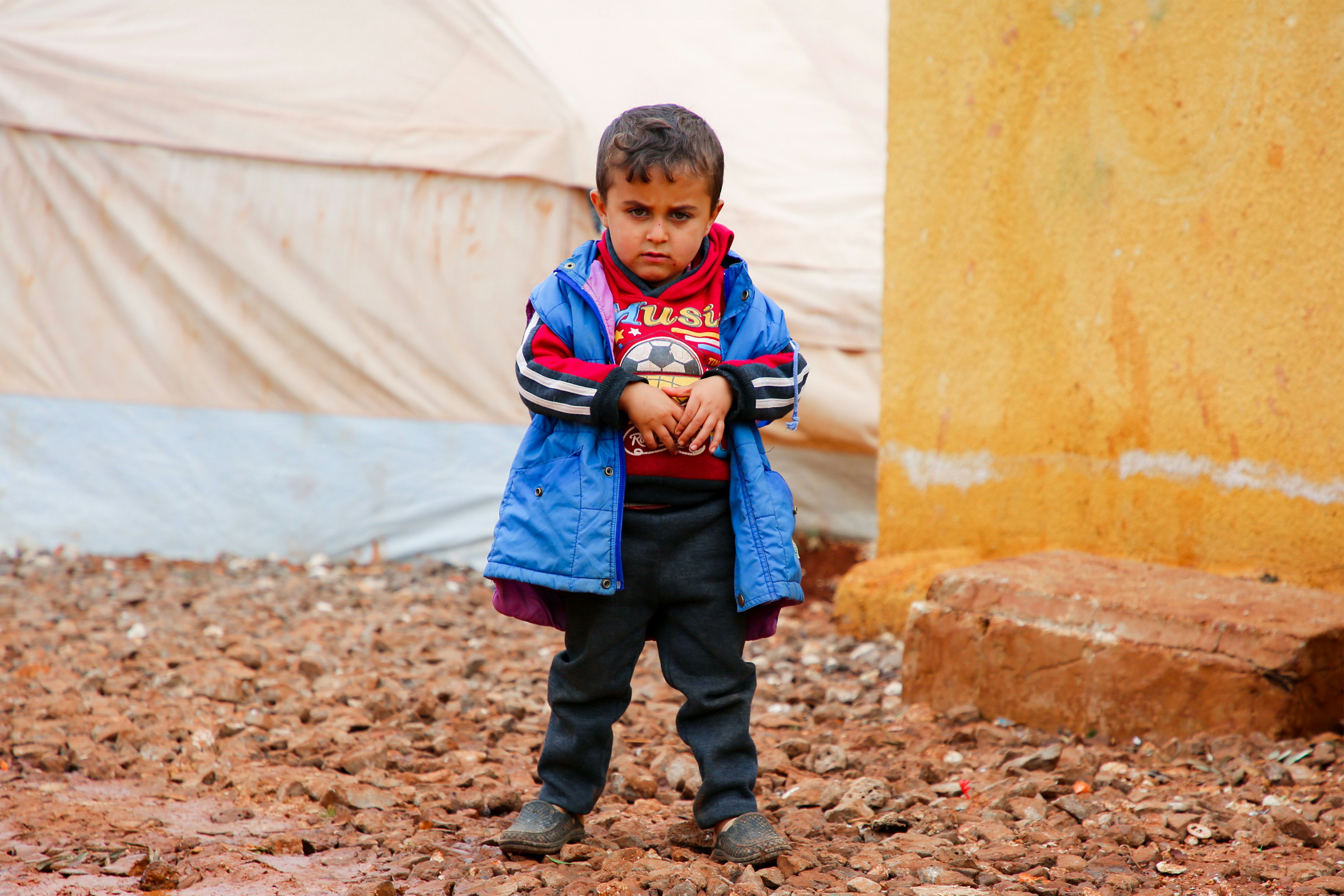 Little boy with ball in dirt