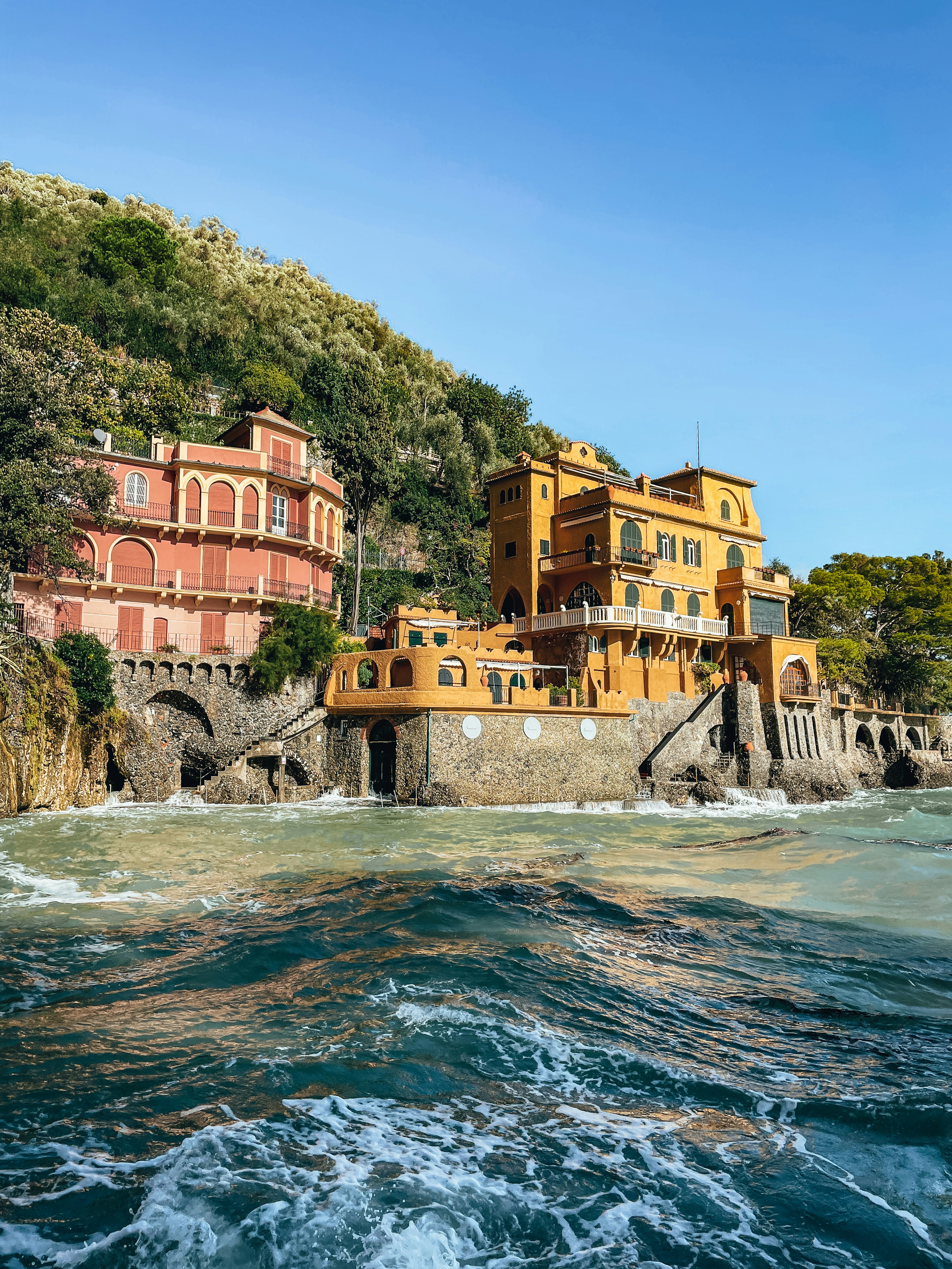 A group of buildings sitting on top of a cliff next to the ocean