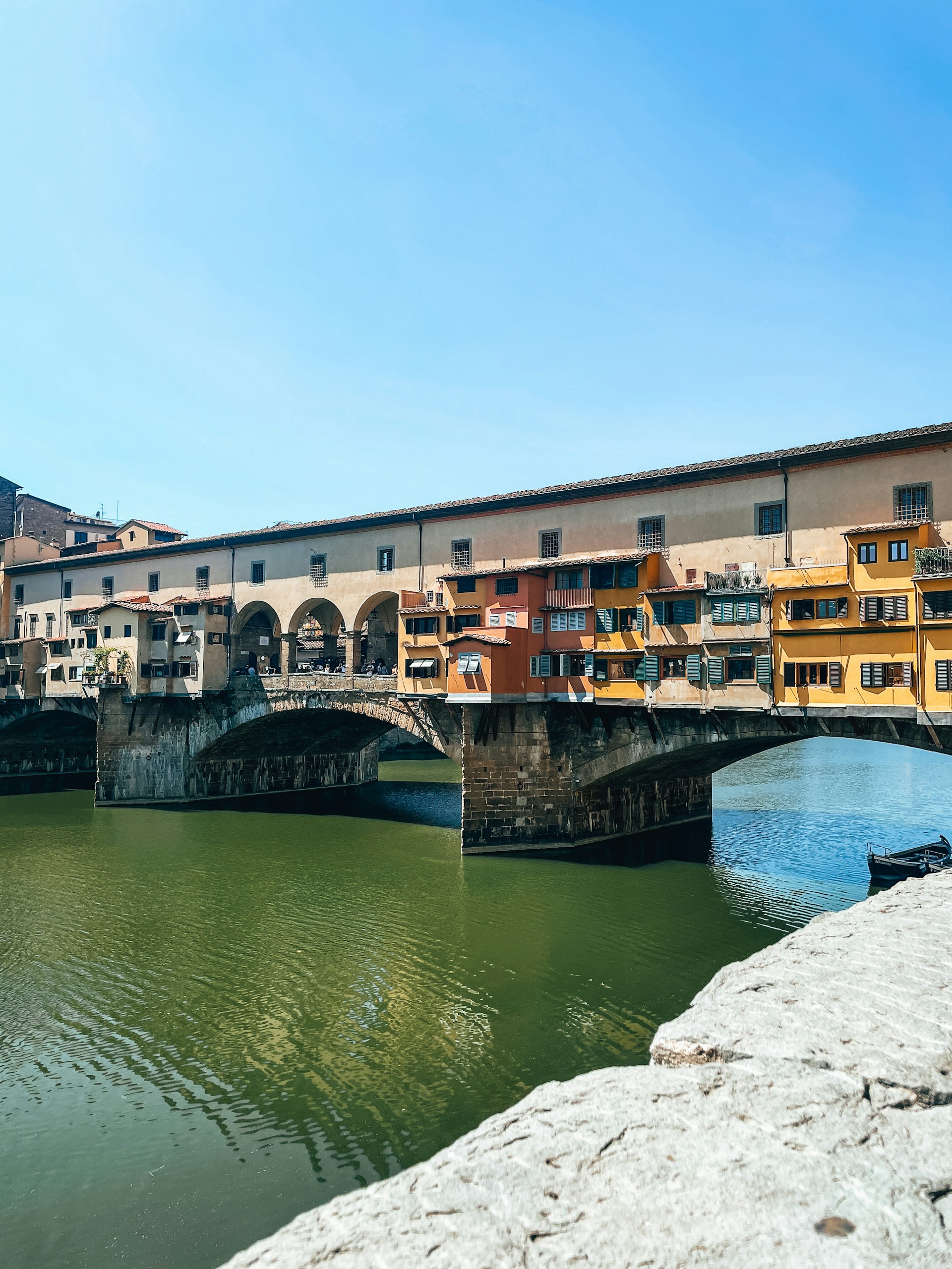 A bridge over a body of water with buildings in the background