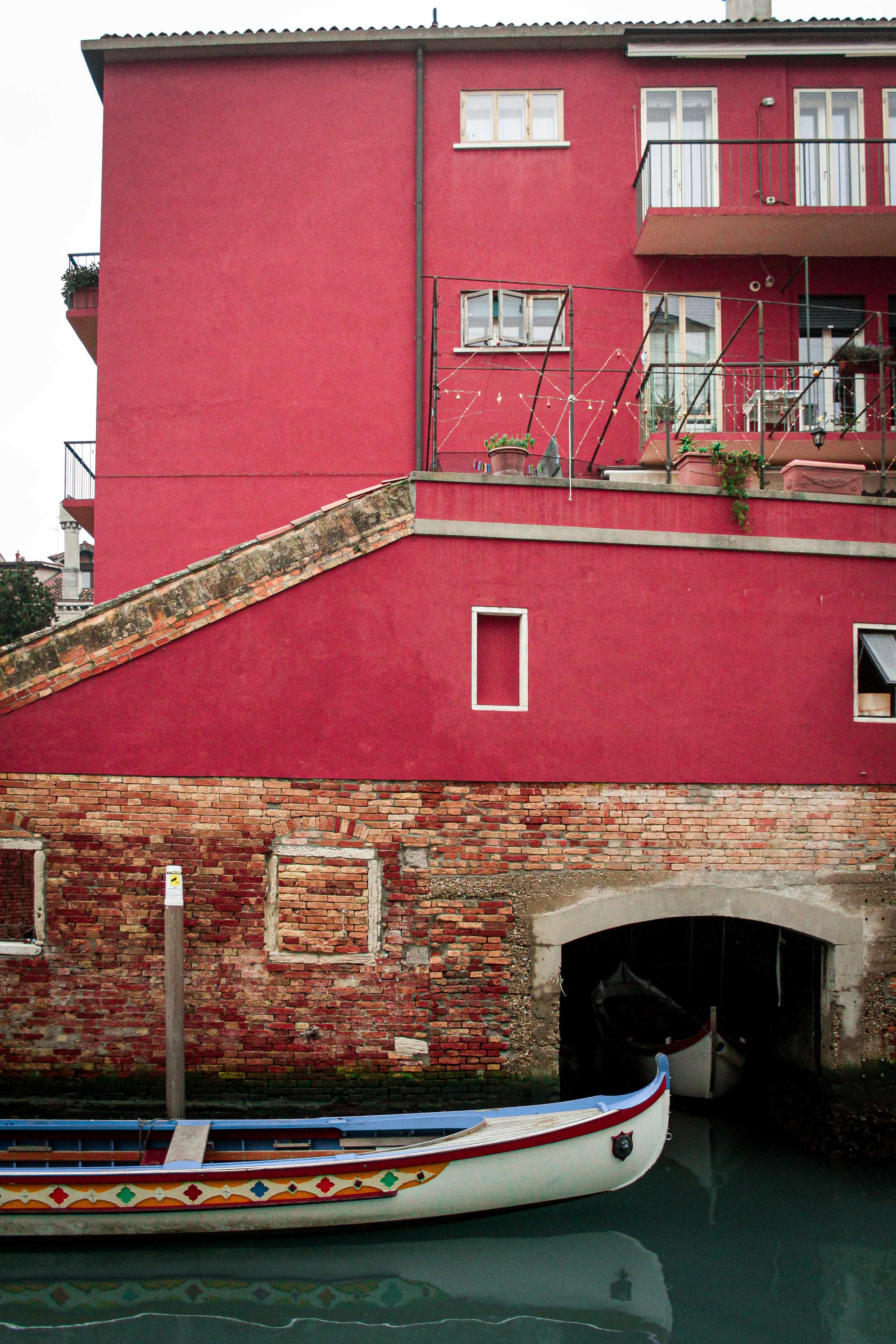 赤い建物の前にボートが停泊しています