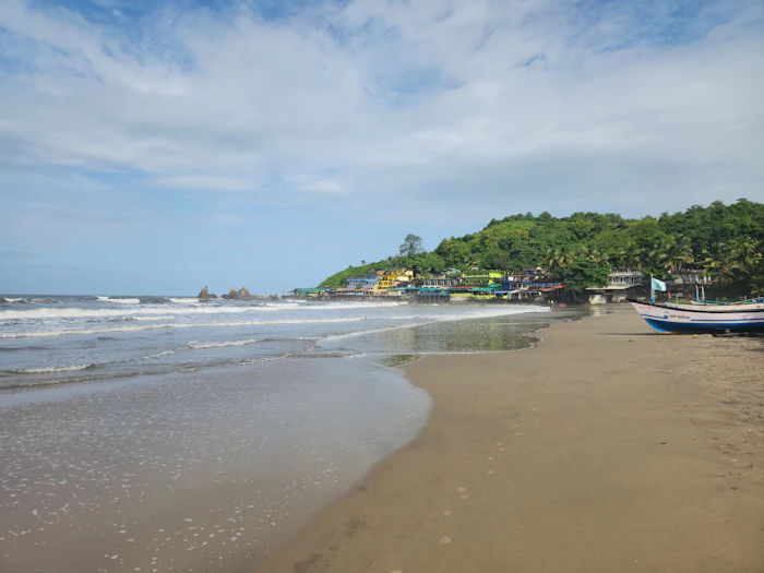 Quiet South Goa beach with a fishing boat and palm trees