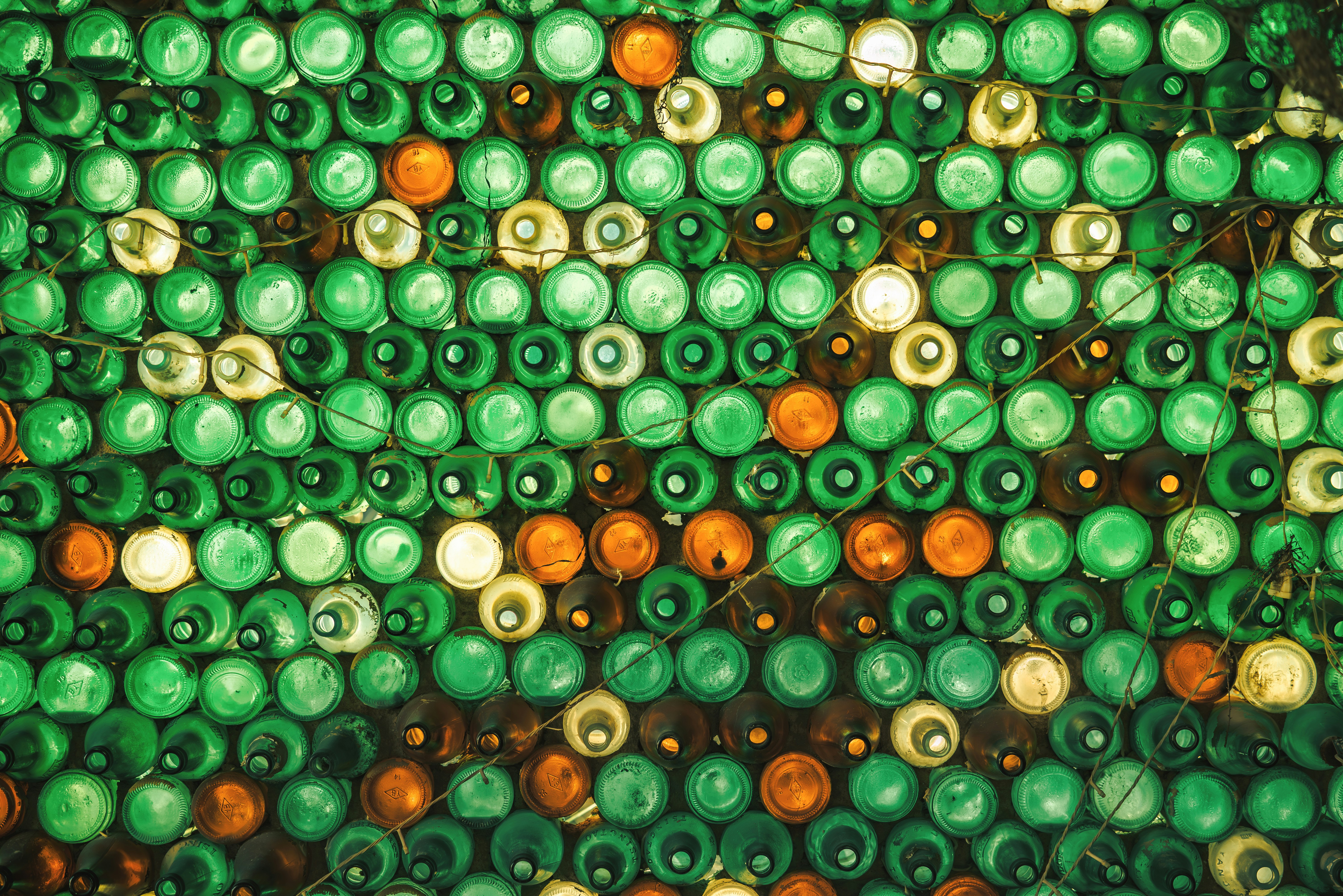 A group of green and orange bottles stacked on top of each other, 