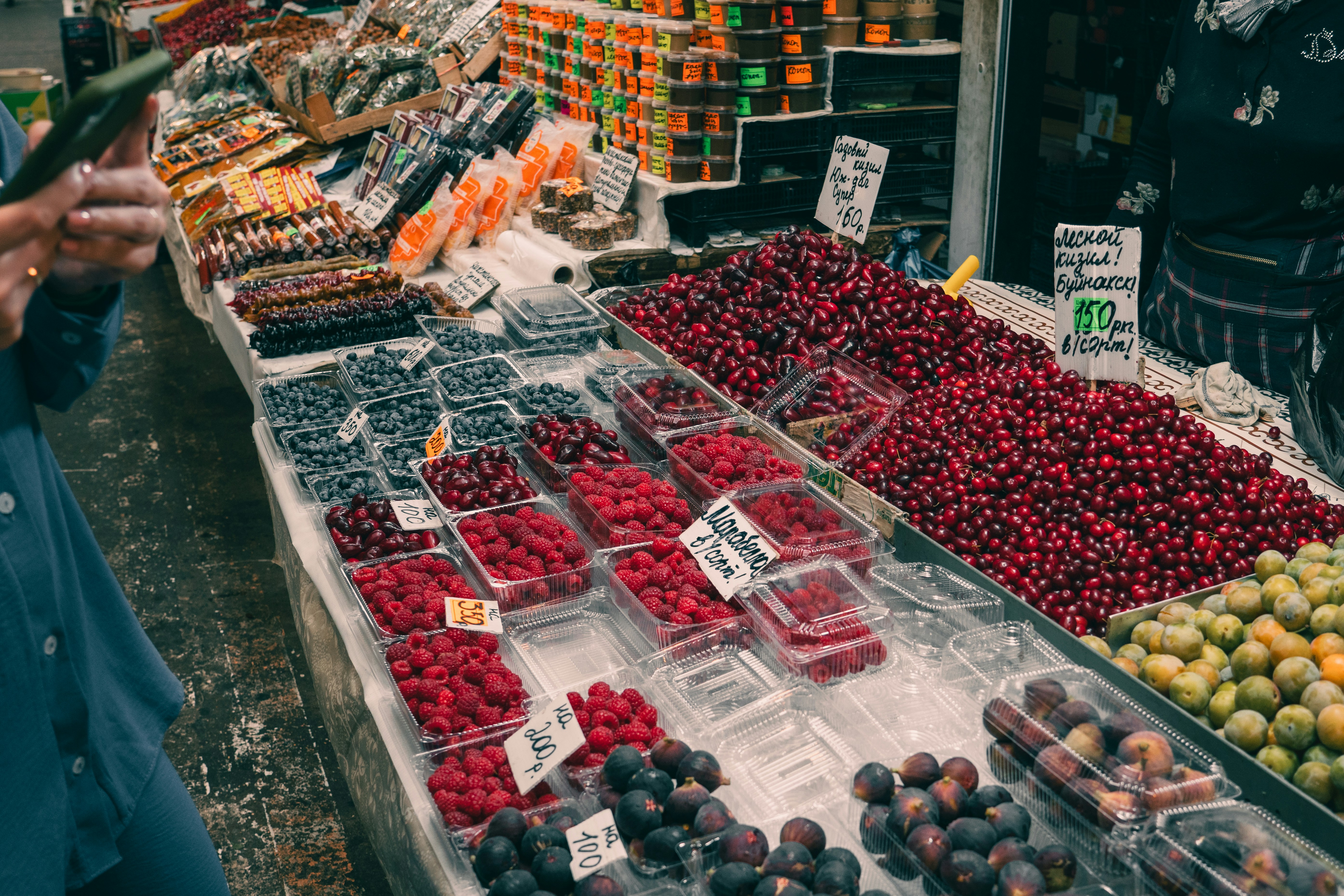 A person standing in front of a fruit stand