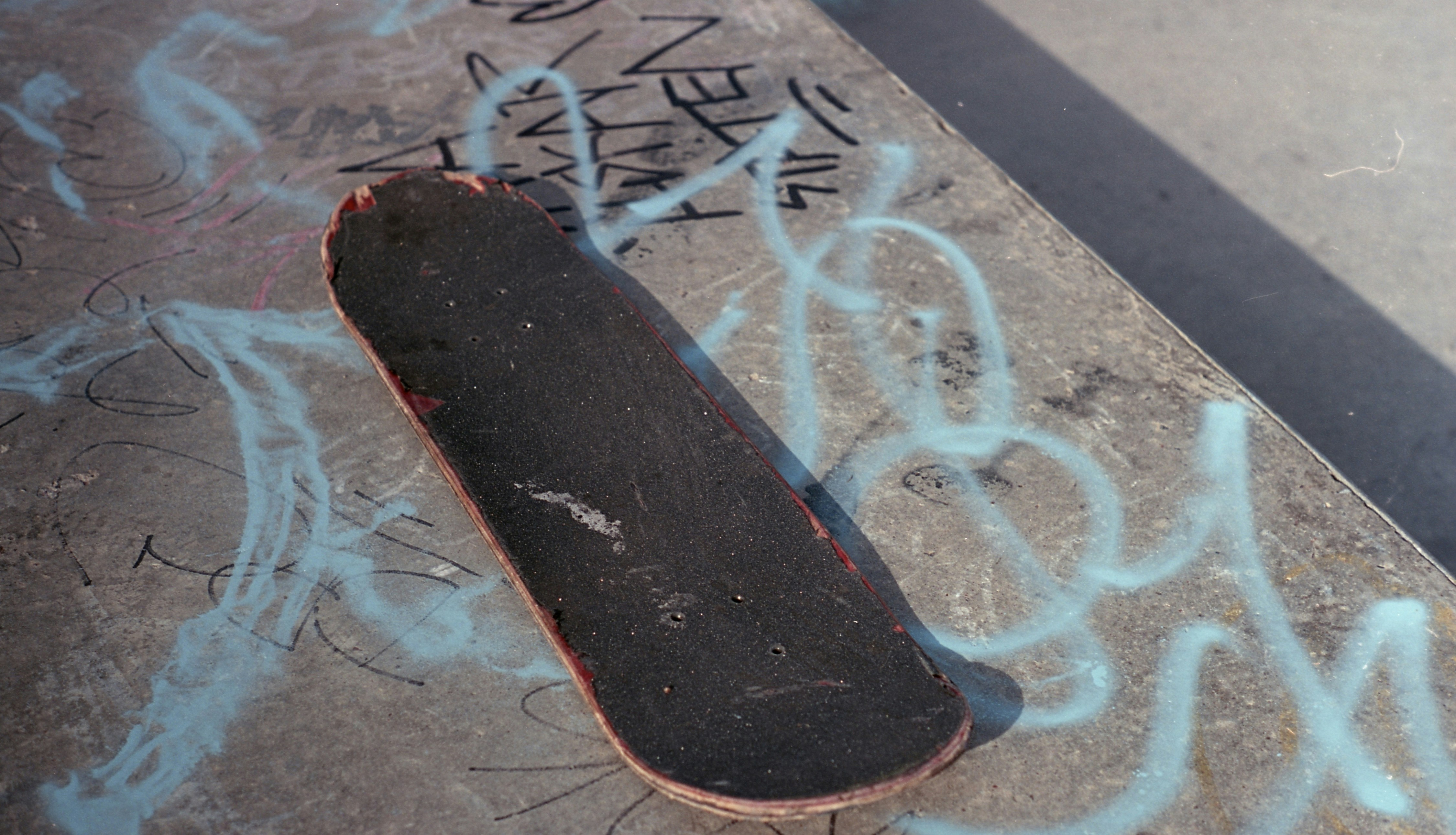 Ein Skateboard, das mit Graffiti auf dem Boden liegt
