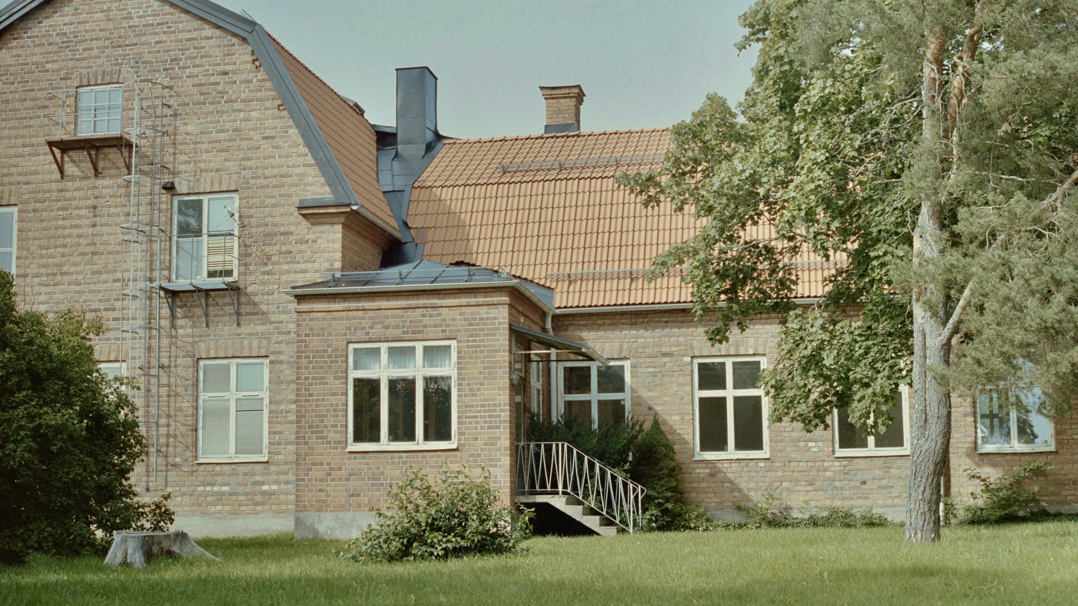 Ein großes Backsteinhaus auf einer üppigen grünen Wiese