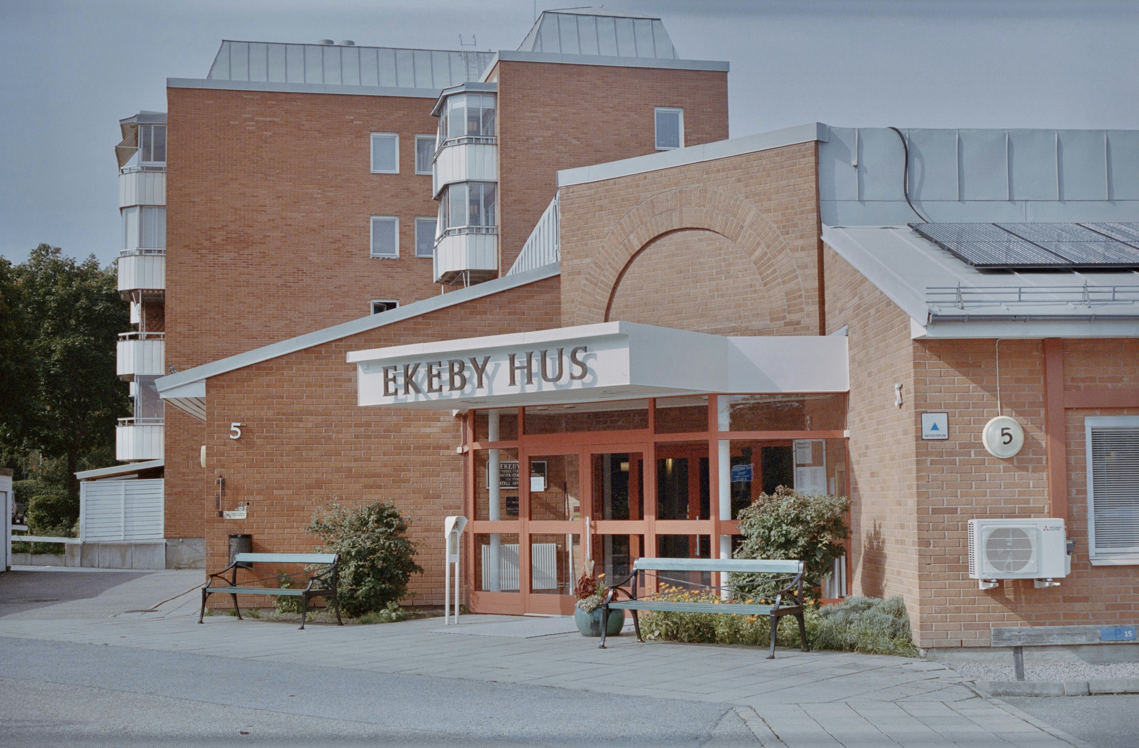 Ein rotes Backsteingebäude mit einem Solarpanel darauf