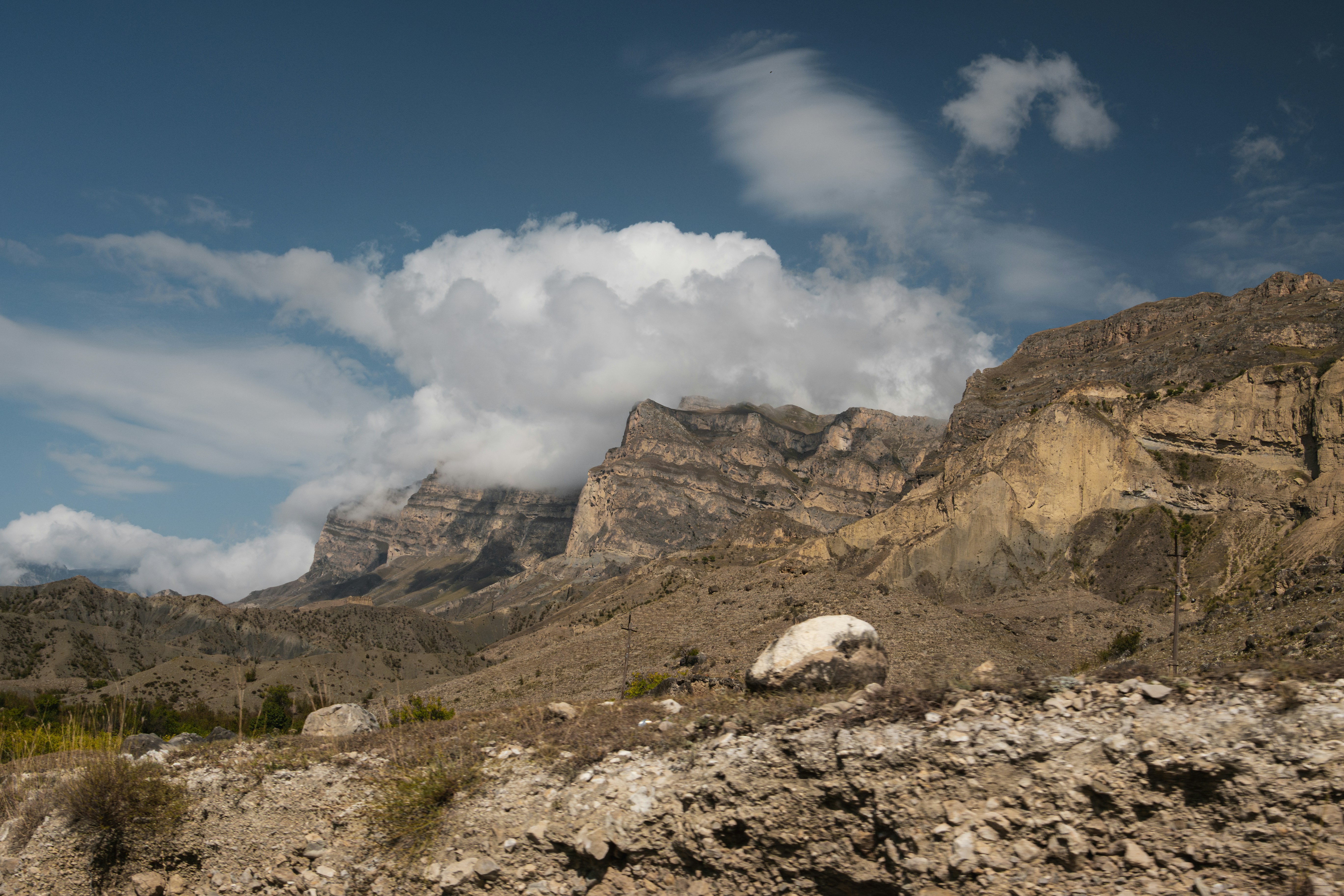 A mountain range with a few clouds in the sky
