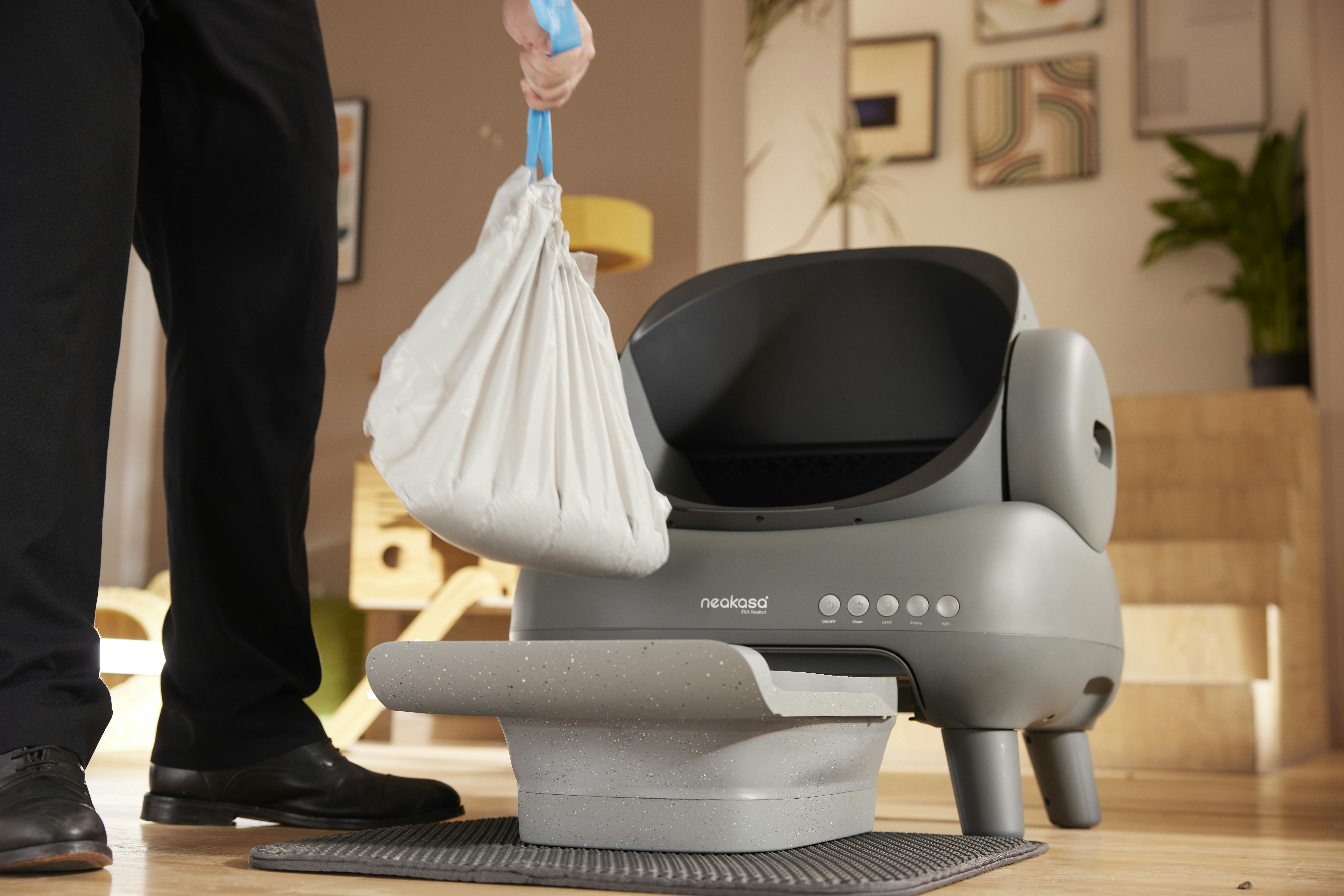 A man standing next to a robot vacuum