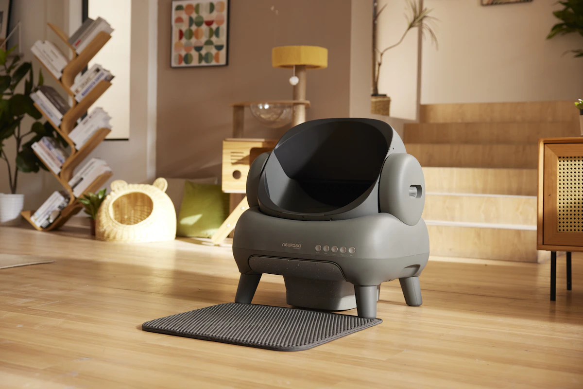 Litter box setup in a clean corner of a home with wooden flooring